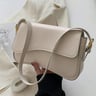 Beige leather shoulder bag with gold hardware and front flap.