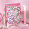 Miniature 3D scene book with pink cover and cartoon illustrations, spiral bound, with small plastic tool on pink surface.